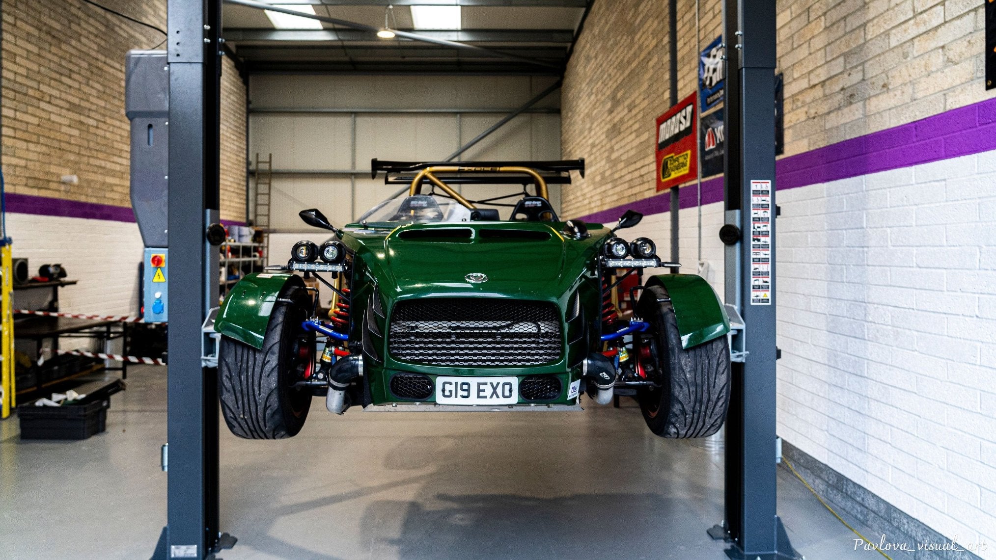 Dark green Exocet lifted on the ramp, workshop in the background