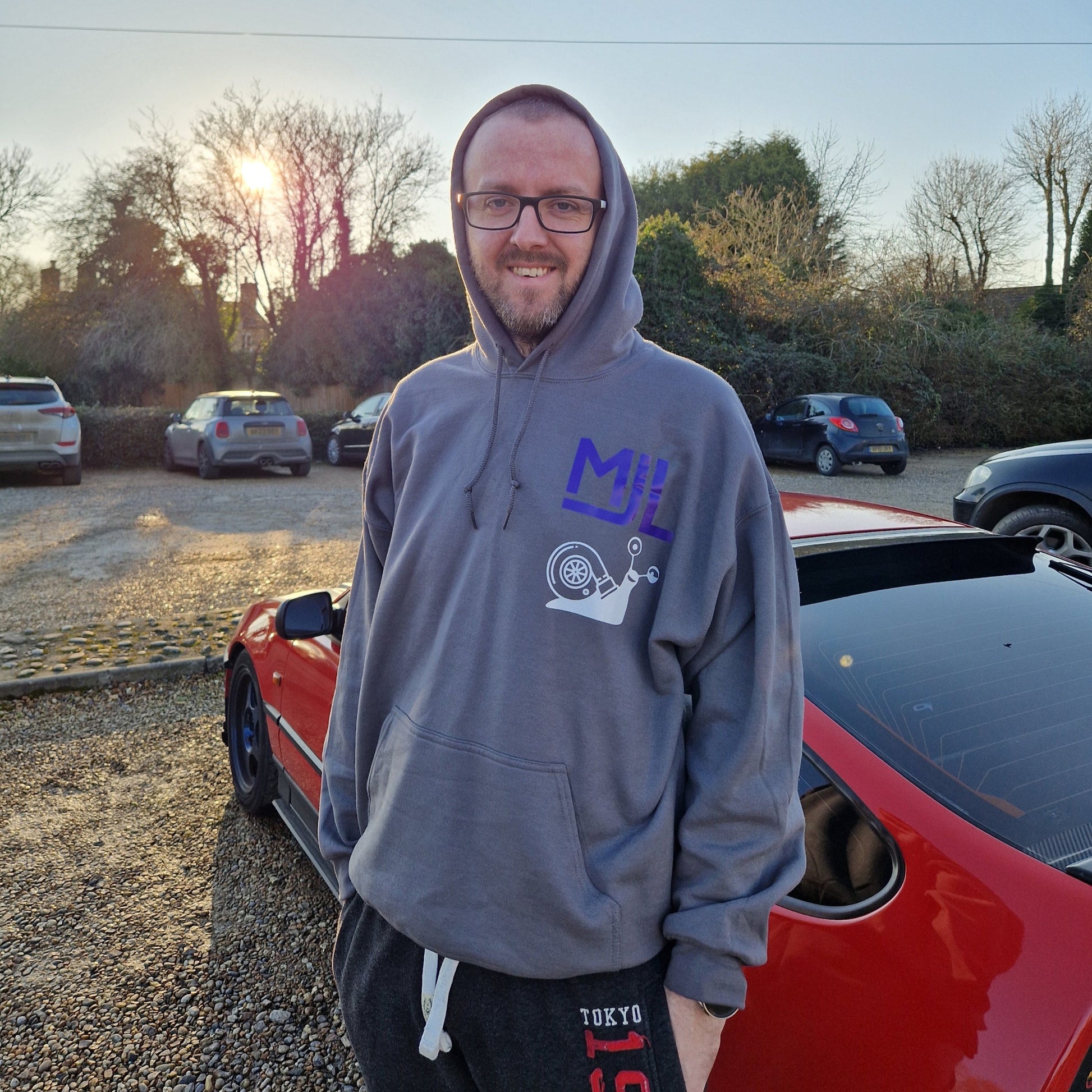 A person wearing  hoodie featuring MJL Motorsport logo